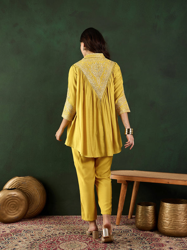 Close-up of floral embellishments on yellow tunic